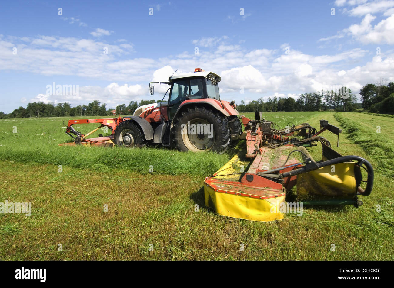 Faucher l'herbe d'ensilage avec tracteur Steyr et Fella faucheuse montée avant et arrière, la Suède Banque D'Images