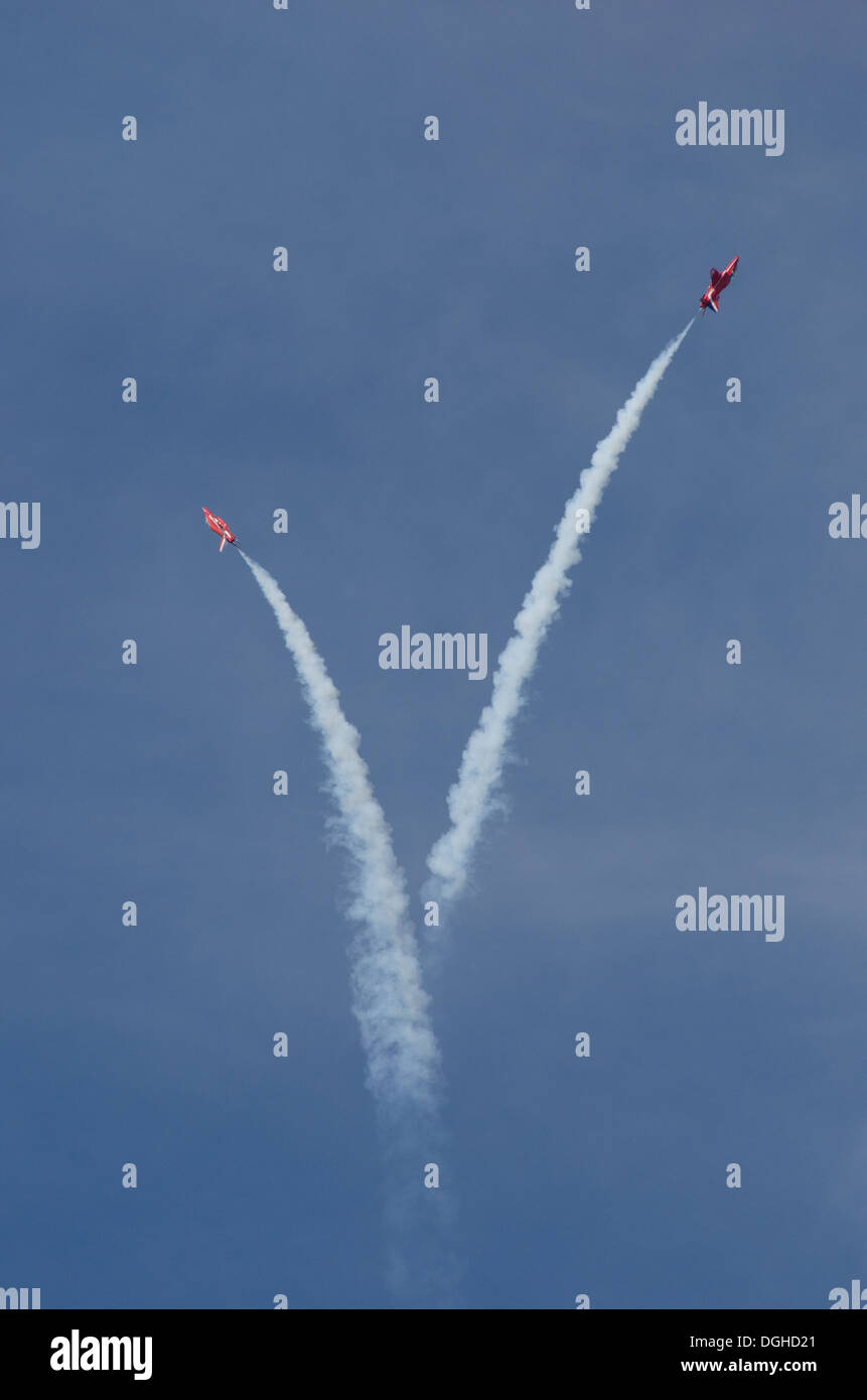 Deux flèches rouges RAF effectuer une manœuvre acrobatique en formation avec la fumée à l'Airshow 2013 Southport Banque D'Images