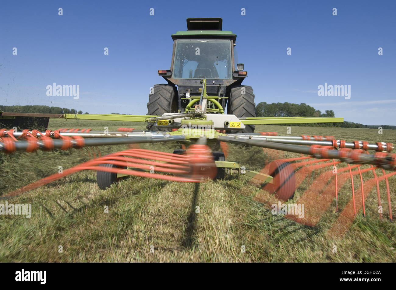 Tracteur Claas Liner 350 avec râteau, en tournant l'herbe coupée pour la récolte de l'ensilage, la Suède Banque D'Images