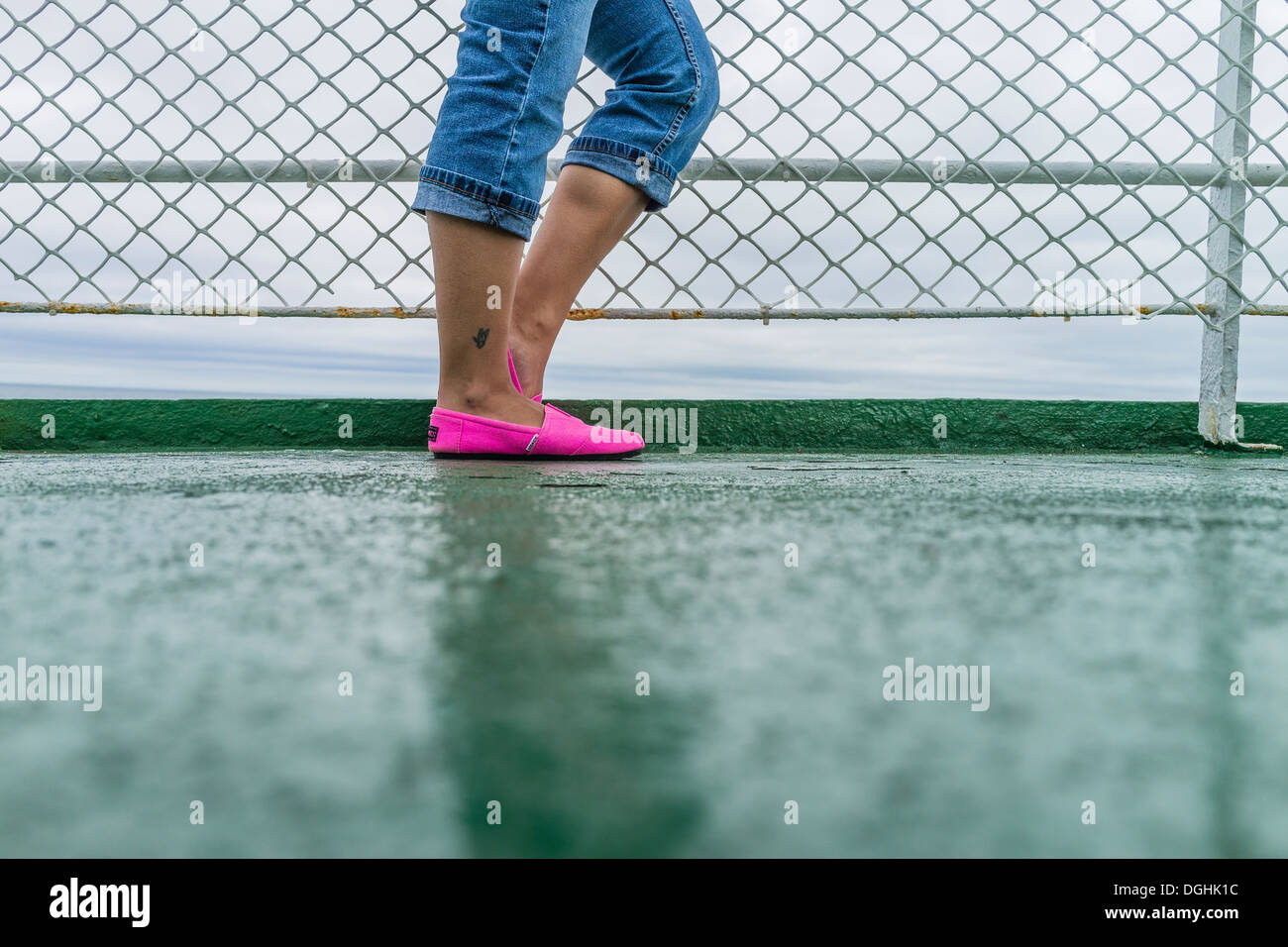 Les adolescents au-dessous de la taille vers le bas avec un jean retroussé et bright pink slip-on chaussures à garde-corps de traversier, PEI, Canada Banque D'Images