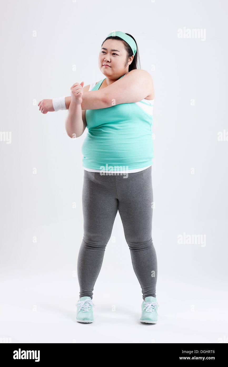 Une grosse fille qui s'étend dans une tenue de sport Photo Stock - Alamy