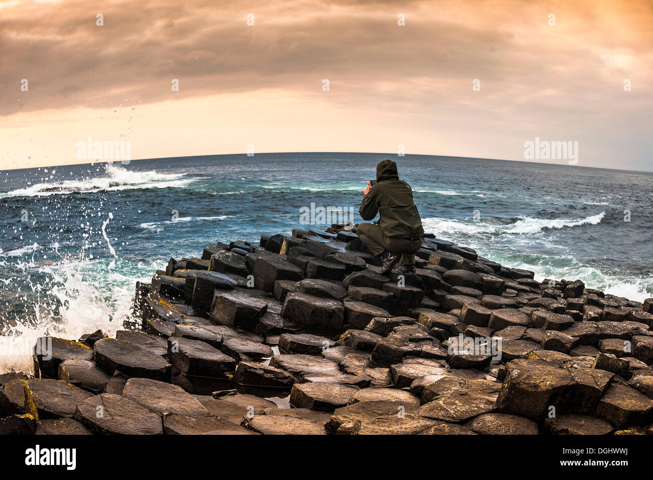 L'homme de prendre des photos avec un smartphone, Giant's Causeway, colonnes de basalte, côte de Causeway, comté d'Antrim, en Irlande du Nord Banque D'Images