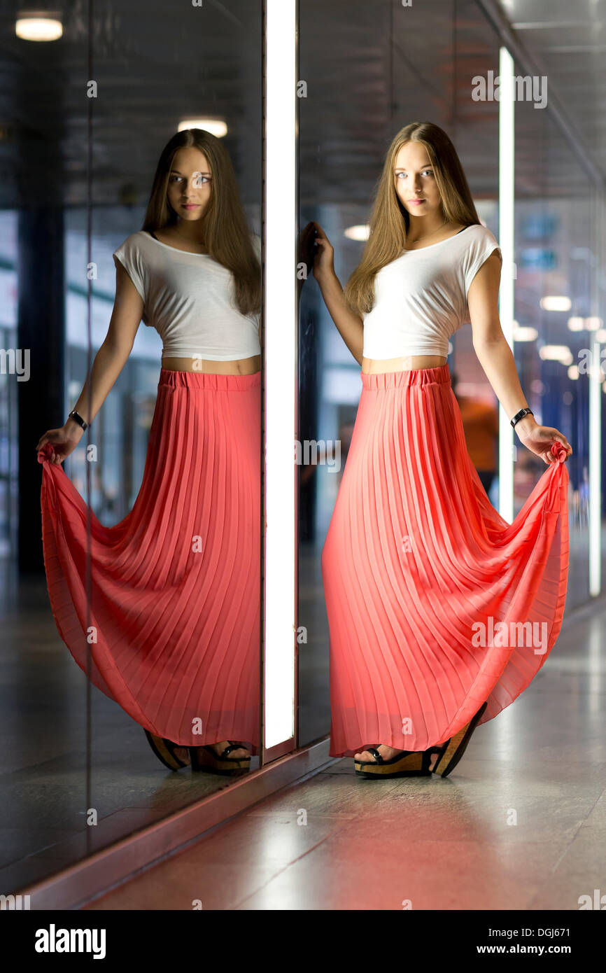 Jeune femme portant un haut blanc et une longue jupe rouge, avec son reflet  Photo Stock - Alamy