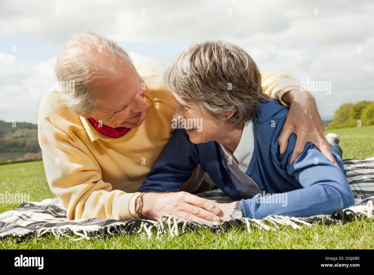 Mari et femme lying on stomach on blanket in field Banque D'Images