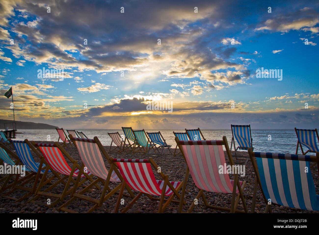 Chaises vides à l'aube sur la plage de la bière dans le Devon. Banque D'Images