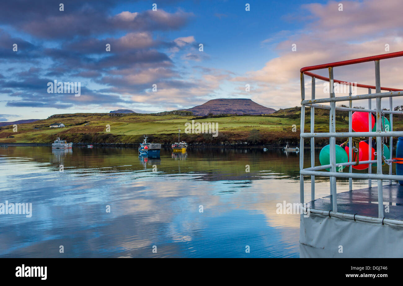 Port de Dunvegan avec la poupe d'un bateau de crevettes à l'avant-plan et les Macleods tables dans la distance. Banque D'Images