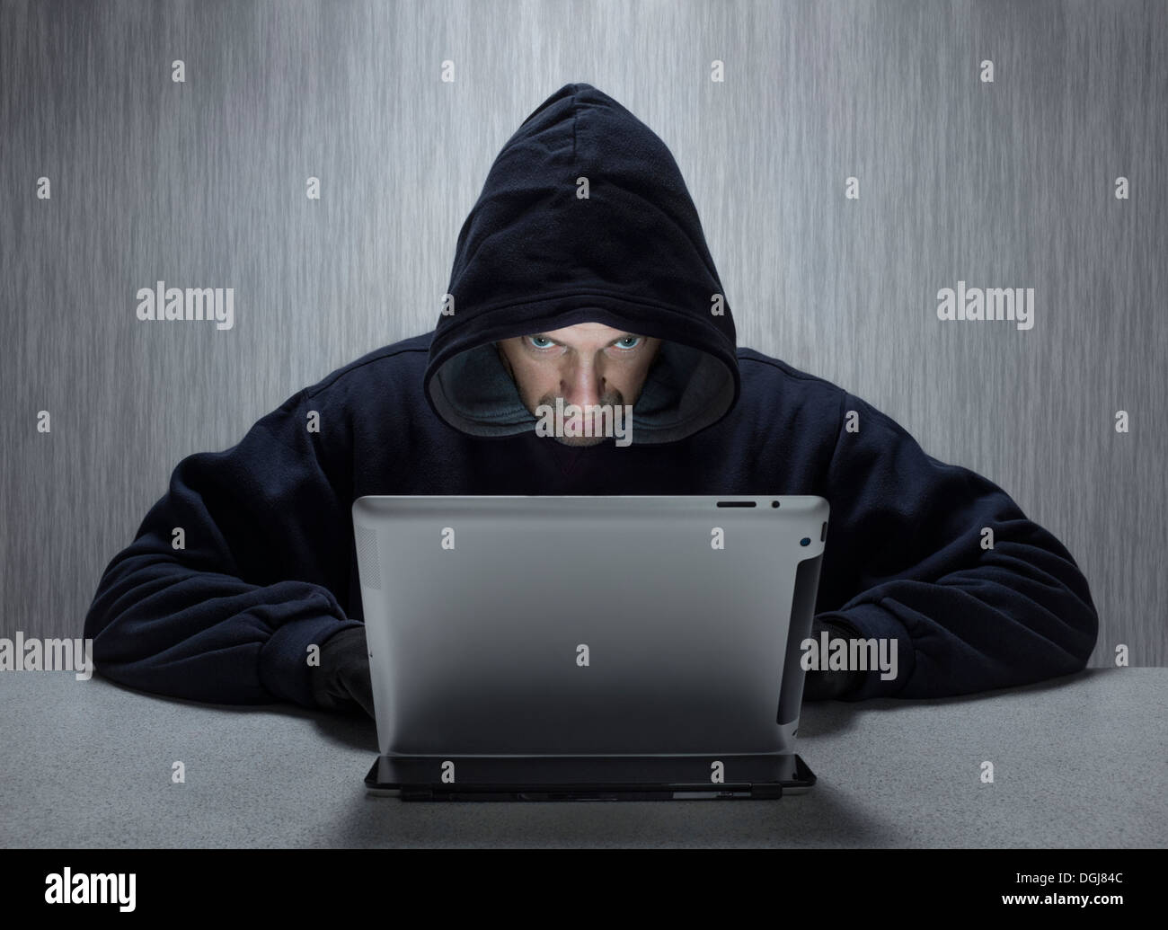 Un homme cagoulé représentant un cyber criminel. Banque D'Images