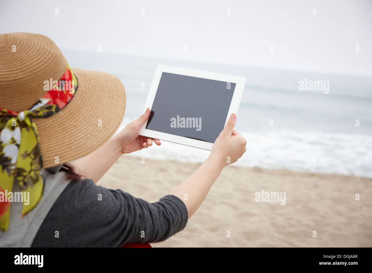 Une personne avec une tablette sur la plage Banque D'Images
