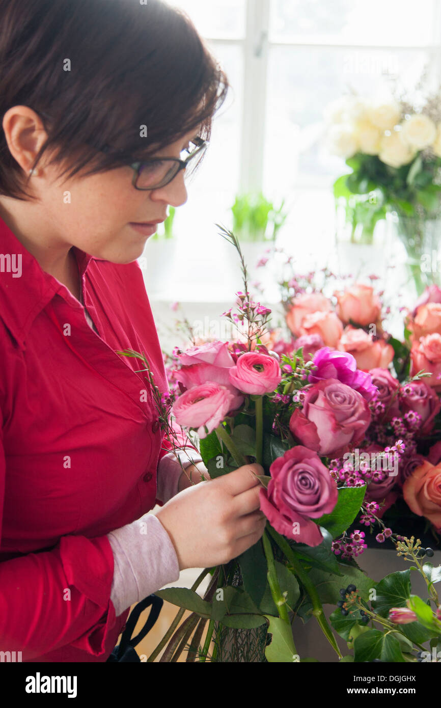Jeune femme organisant des fleurs en bouquet Banque D'Images