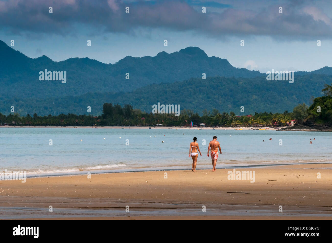 Deux personnes marchant le long de la plage de Pentai Tengah à Langkawi. Banque D'Images