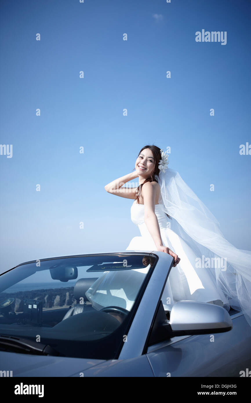 Une épouse assise dans une voiture décapotable Banque D'Images