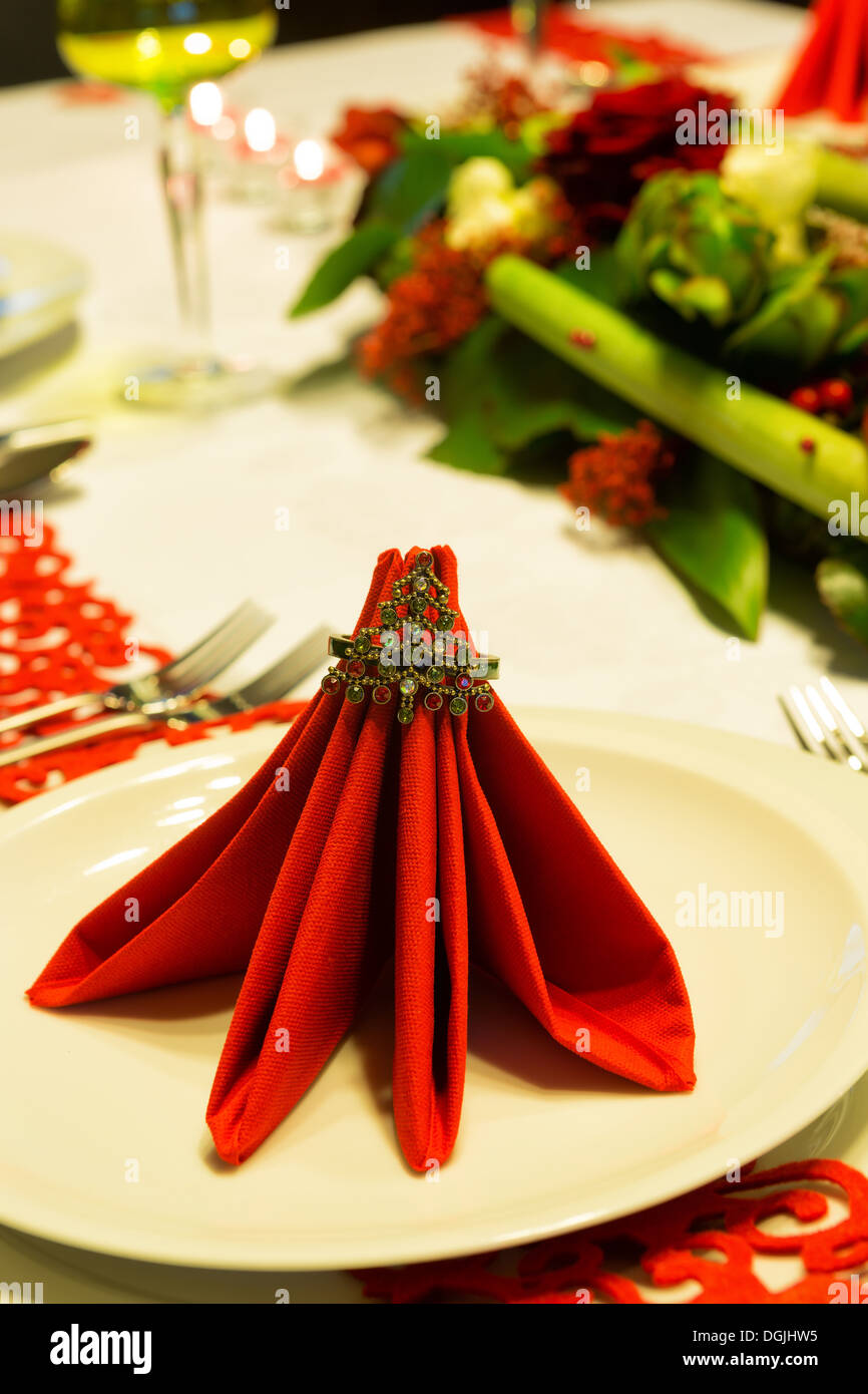 Table de Noël décorée avec des serviettes rouges et arrangement floral Banque D'Images