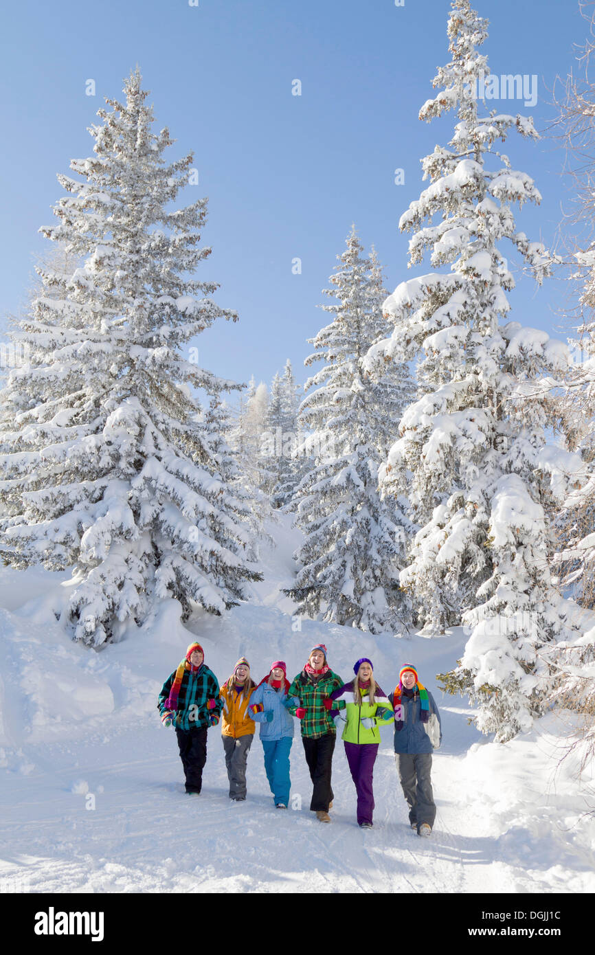 Groupe de jeunes gens marchant à travers un paysage d'hiver, Salzburger Land, Flachau, Tyrol, Autriche Banque D'Images