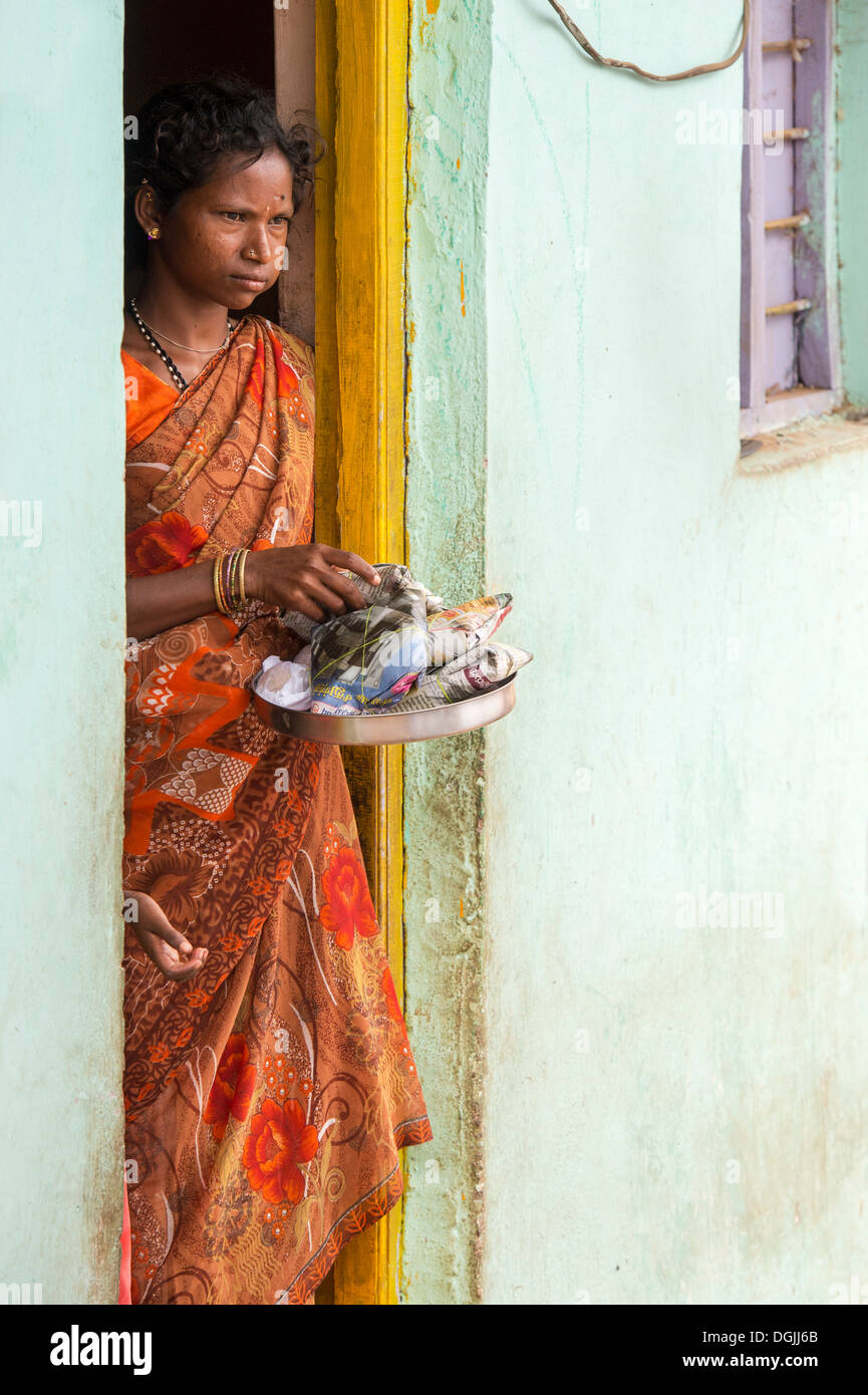 Caste inférieure Indian woman qui reçoivent gratuitement de la nourriture et des vêtements à l'extérieur de sa maison. L'Andhra Pradesh, Inde Banque D'Images
