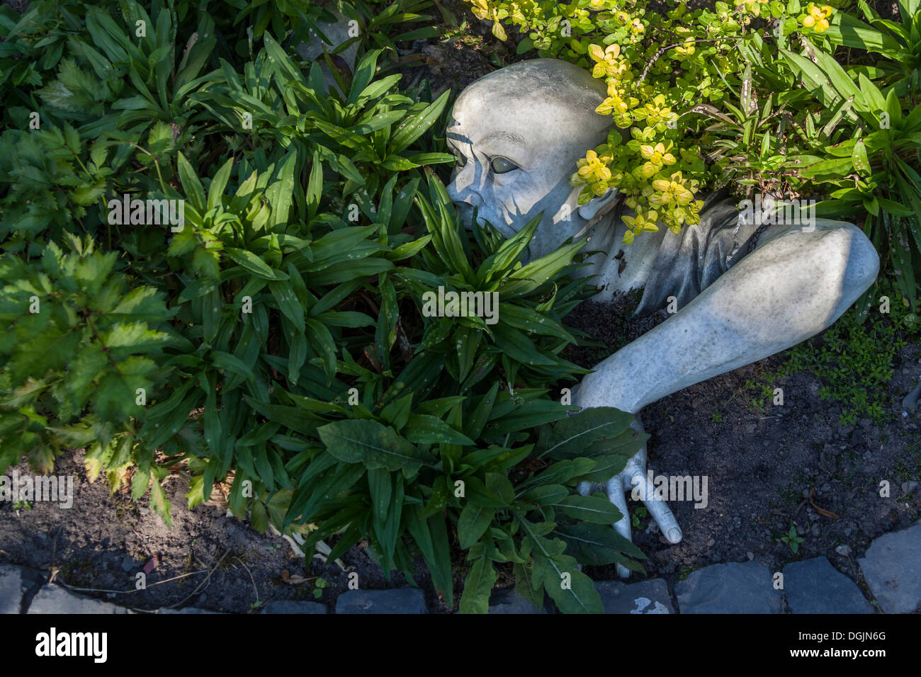Sculpture dans un jardin, l'homme lui-même creuser hors de la terre Banque D'Images