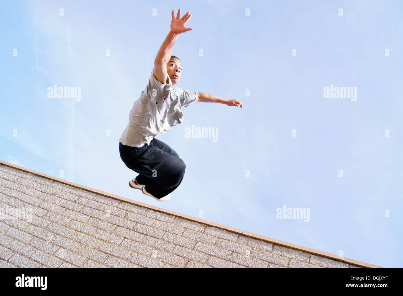 Un athlète parkour sautant par-dessus un mur. Banque D'Images