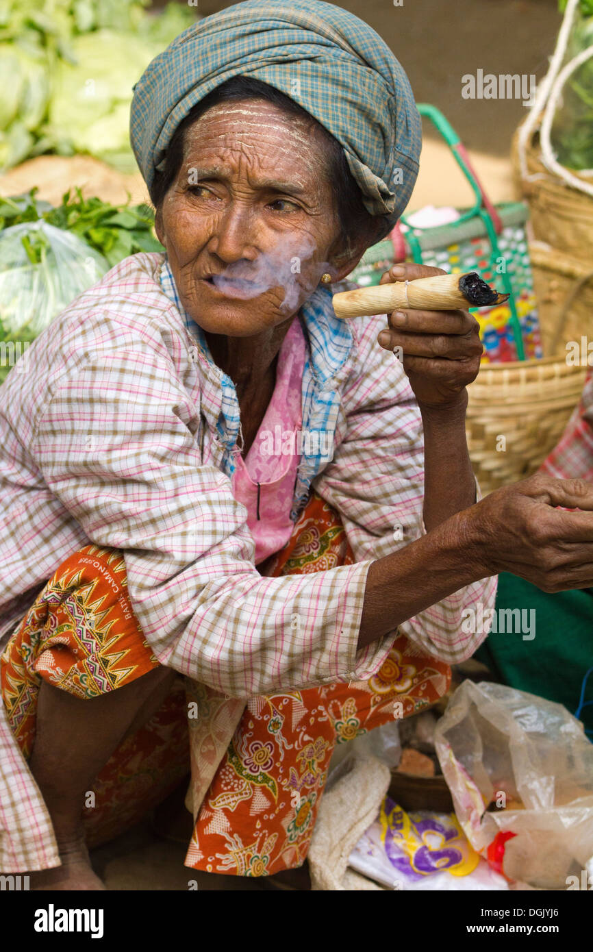 Une vieille femme fumant un cigare dans le marché Nyaung Oo à Bagan au Myanmar. Banque D'Images