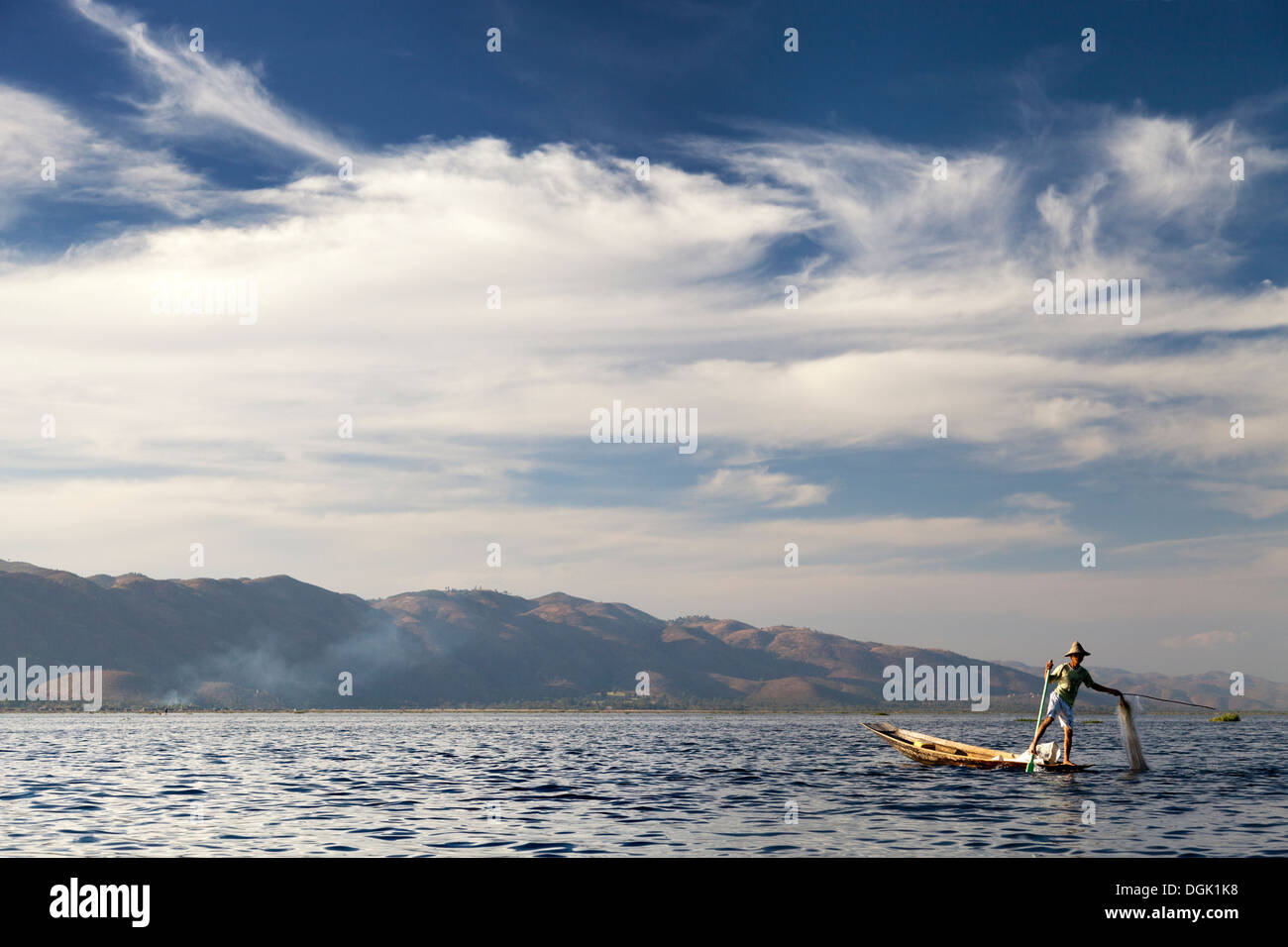 L'aviron et jambe Fisherman casting ses filets sur le lac Inle au Myanmar. Banque D'Images