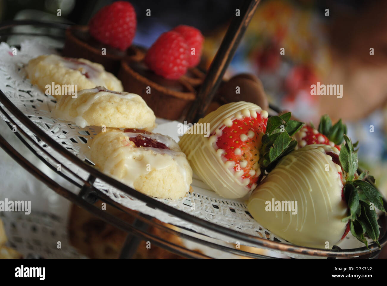 Des fraises au chocolat blanc sur le plateau de service avec d'autres desserts Banque D'Images
