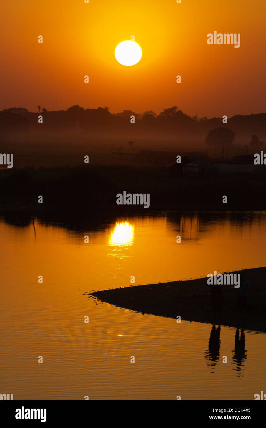 Spectaculaire coucher de soleil sur les rizières et les pagodes vu de pont en teck U Bein au Myanmar. Banque D'Images