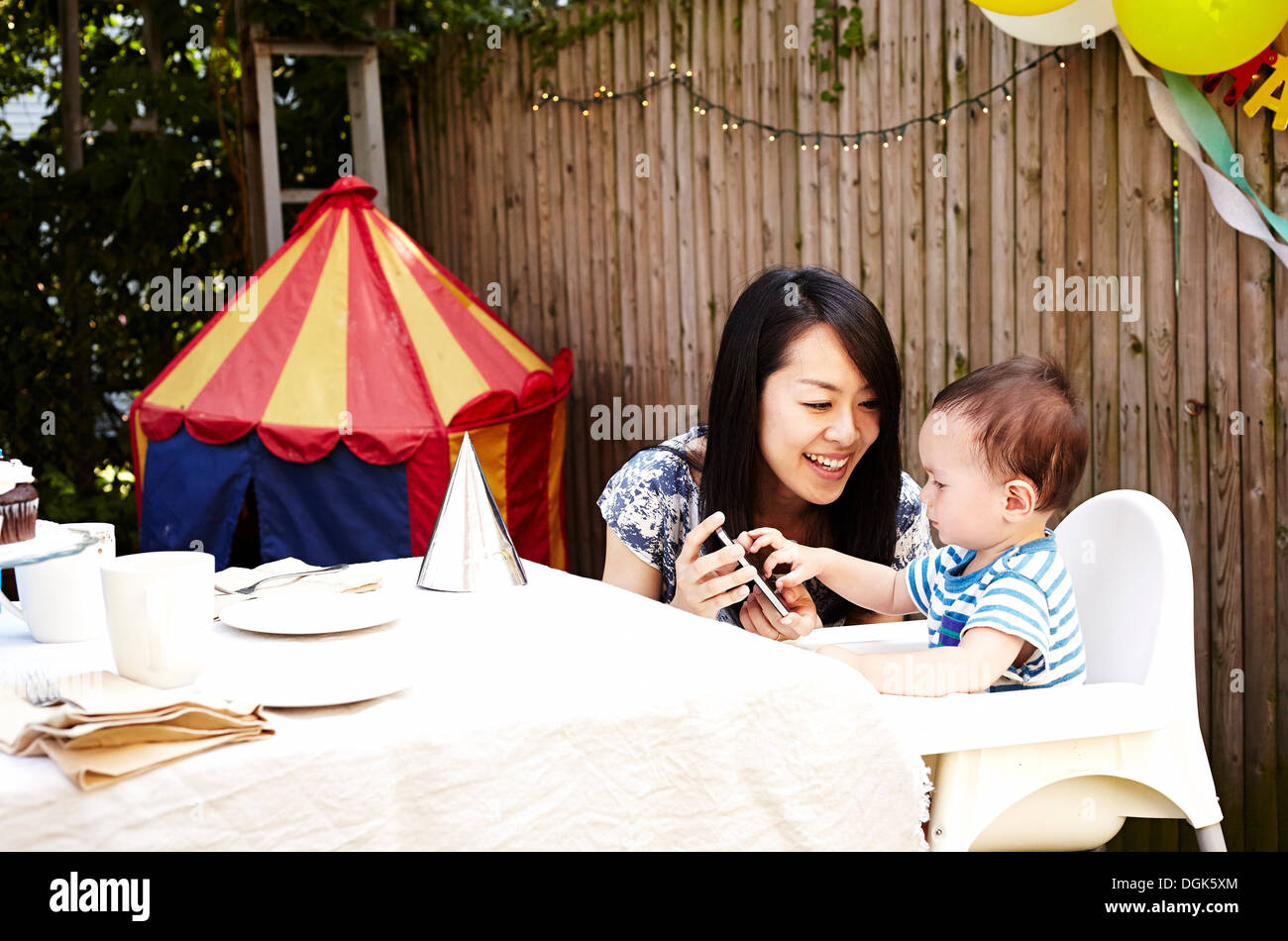 La mère et l'enfant looking at smartphone Banque D'Images