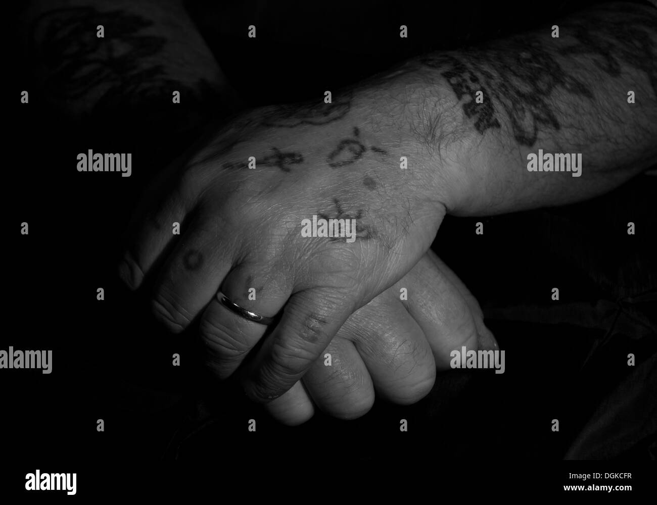 A mains de pères, couvertes de tatouages, mains travaillantes en noir et blanc Banque D'Images