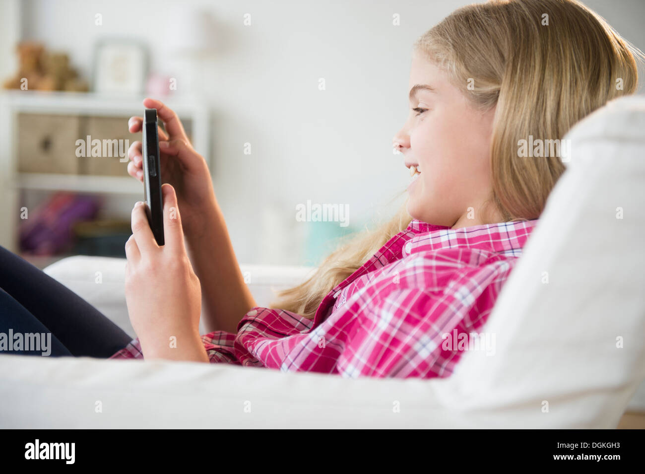 Girl (8-9) reading e-reader Banque D'Images