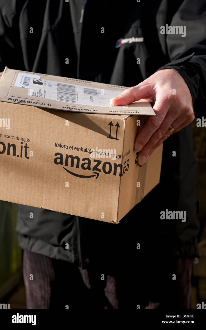 Un homme tenant un Amazon livraison. Banque D'Images