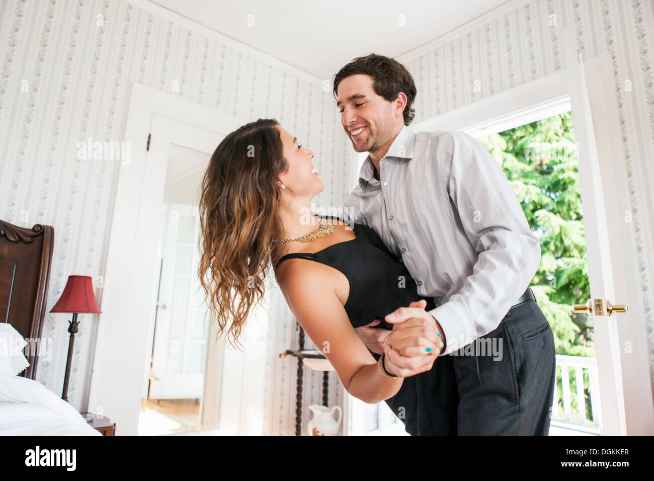 Young couple dancing in bedroom Banque D'Images