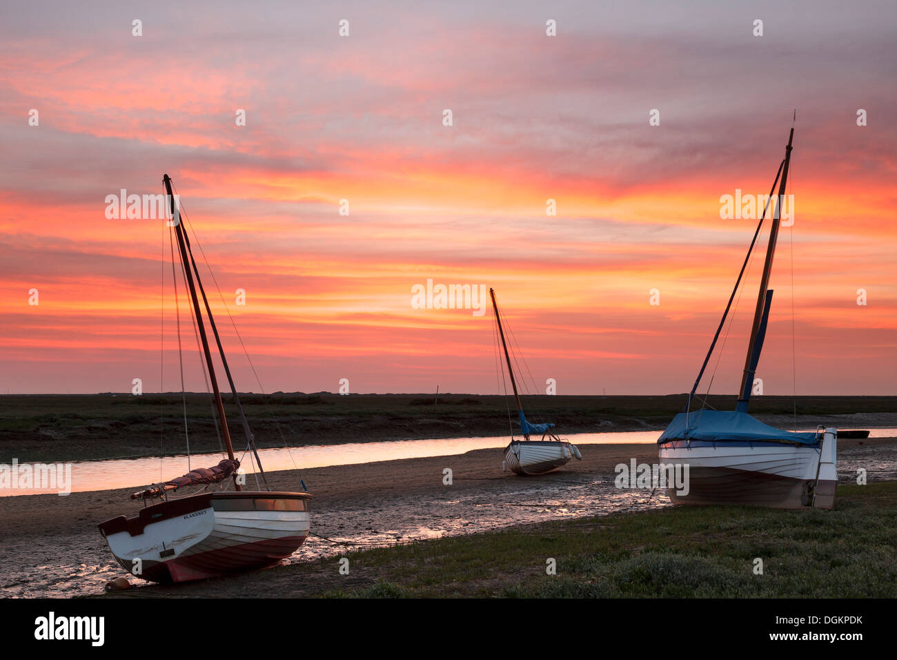 Trois bateaux en bois en attendant le retour de la marée au coucher du soleil. Banque D'Images