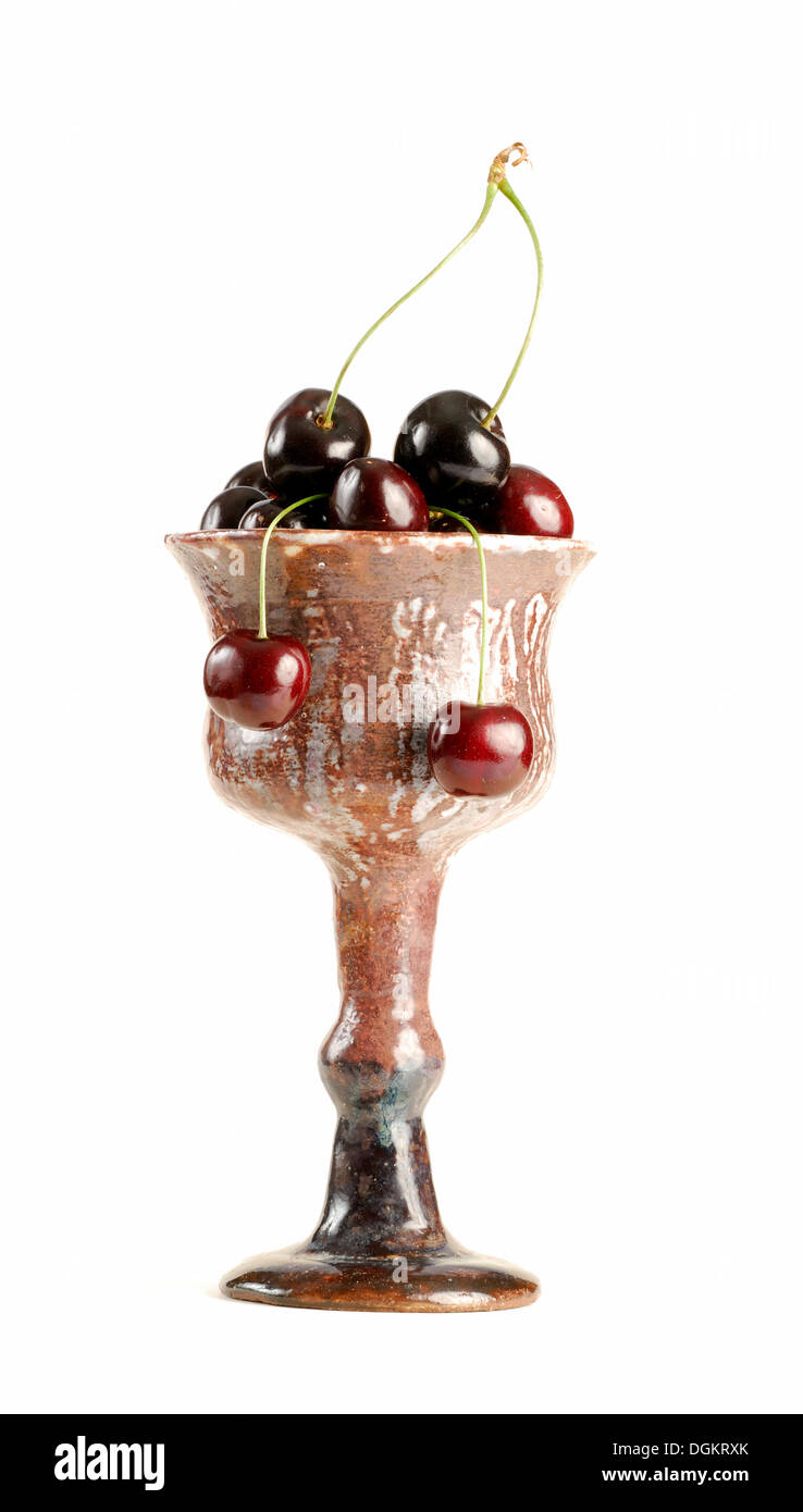 Les cerises dans une tasse de faïence, de cerise noire ou le merisier (Prunus avium) Banque D'Images