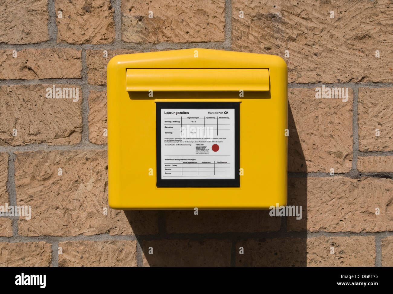 Boîte aux lettres jaune de la Deutsche Post avec un tableau de collecte quotidienne Banque D'Images