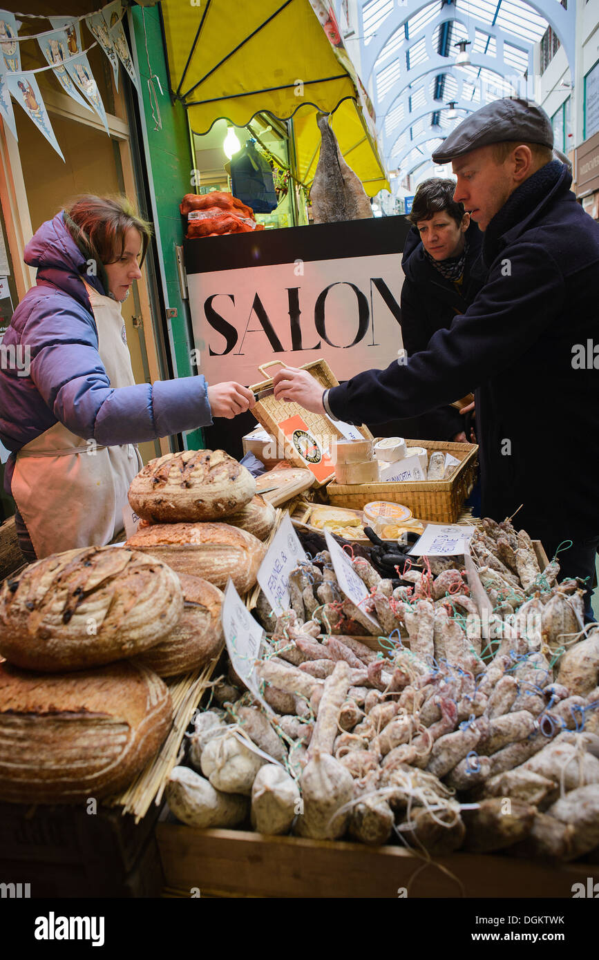 Les clients d'essayer des échantillons à un fromage gastronomique et saucisse shop à Brixton Village. Banque D'Images