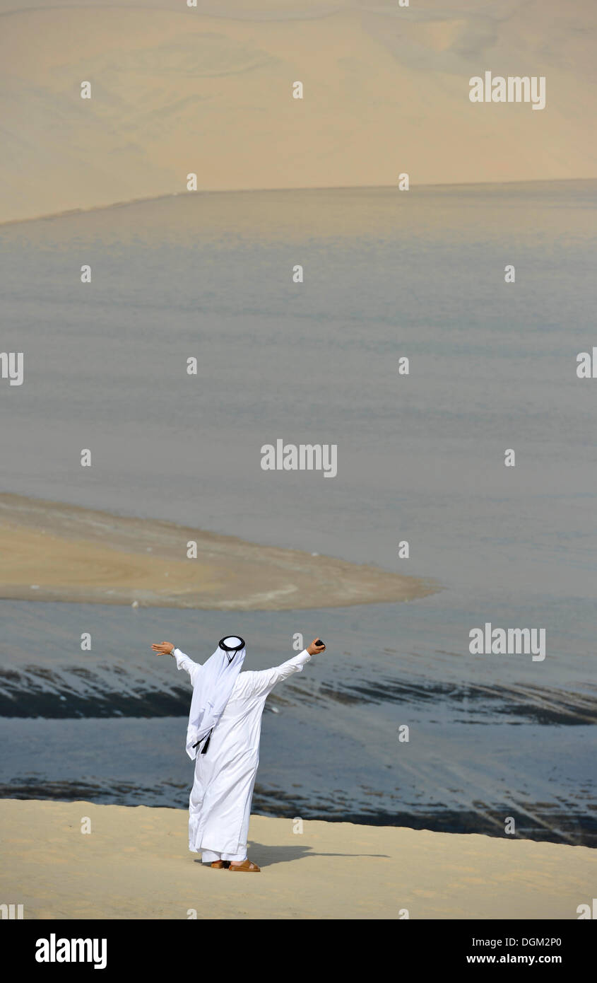 En costume traditionnel qatari avec gutra, en face de la plage de Khor Al Udeid, Khor El Deid, Mer Intérieure, desert miracle du Qatar Banque D'Images