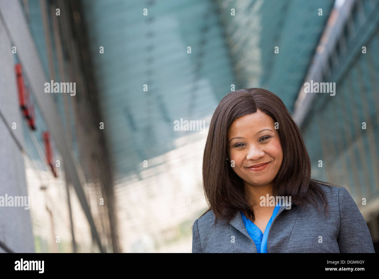 L'été. Une femme dans un costume gris avec une chemise bleu vif. Banque D'Images