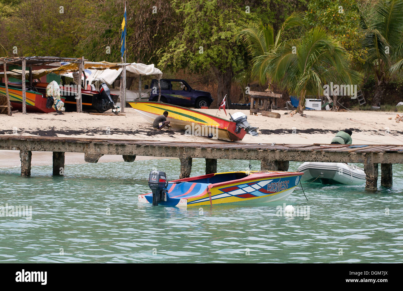 Sifflet sel Bay, jetée, Taxis, l'eau et les hommes en bateau sur la plage, avec des arbres et de stockage, Mayreau, Tobago Cays, le Parc Marin : Sai Banque D'Images