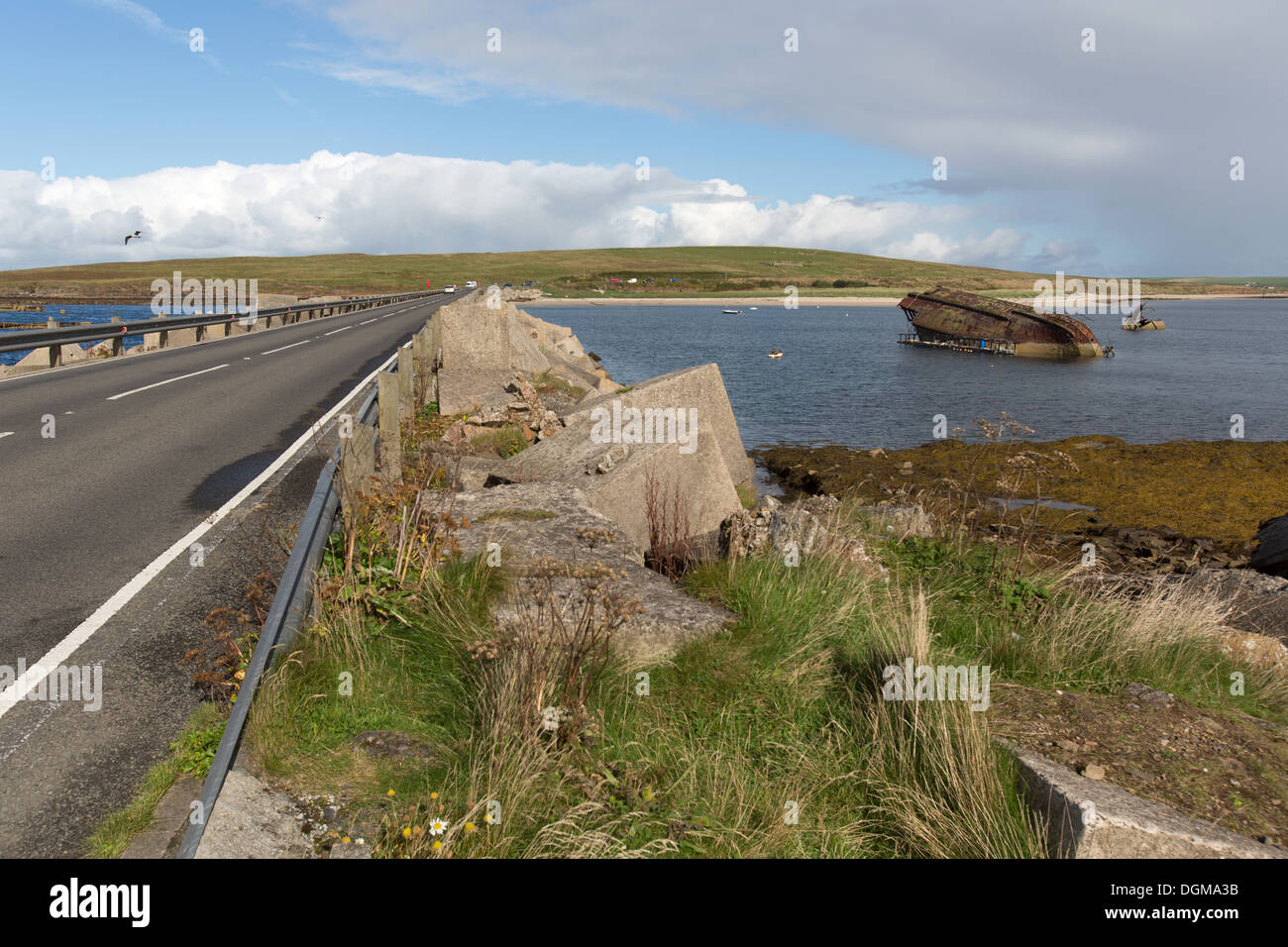 Des îles Orcades, en Écosse. L'A961 à barrière Churchill numéro 3 avec un blockship engloutie dans l'arrière-plan. Banque D'Images