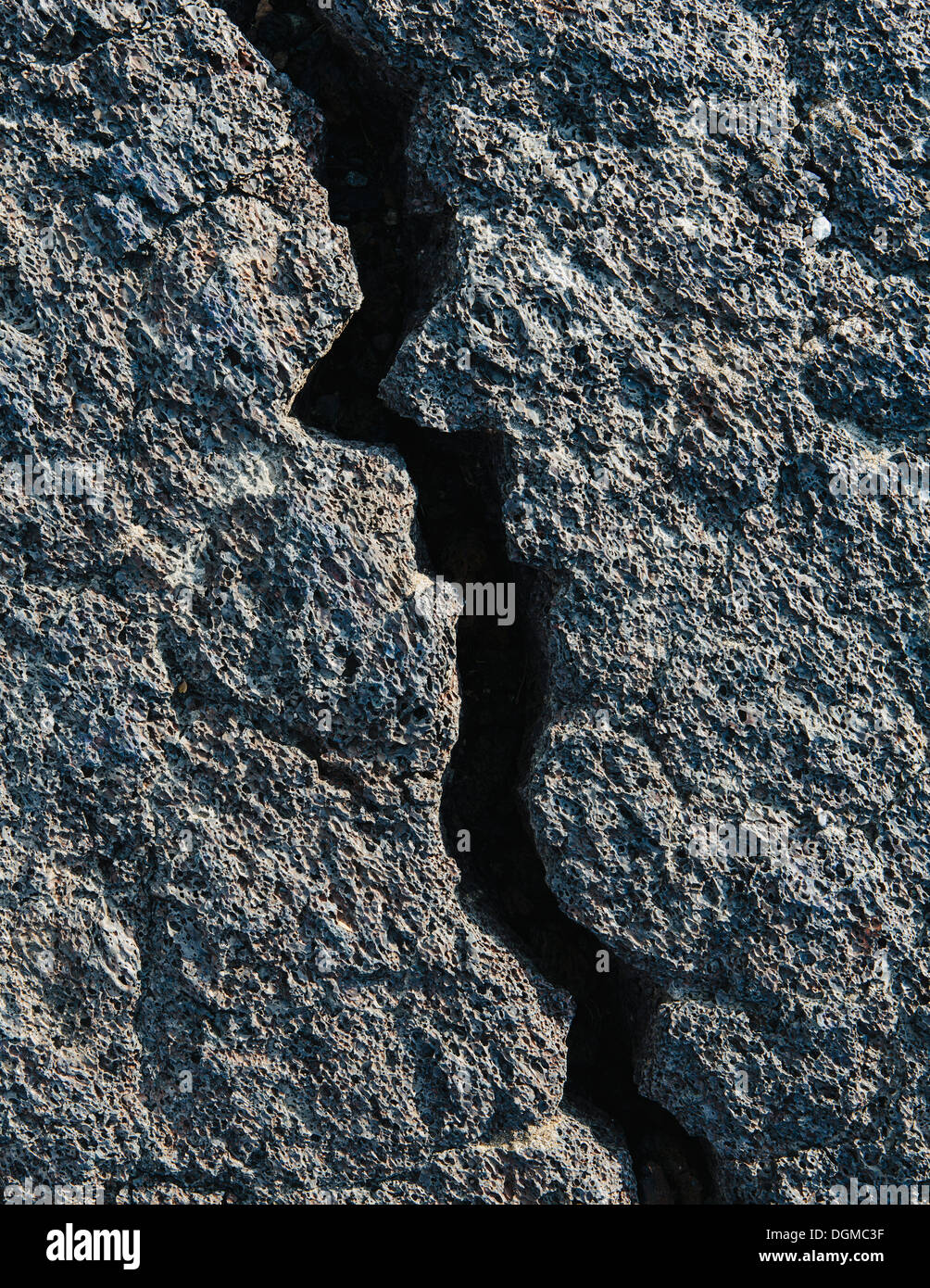 Un champ de lave solidifiée noire, avec des roches de surface, avec des fissures. Banque D'Images