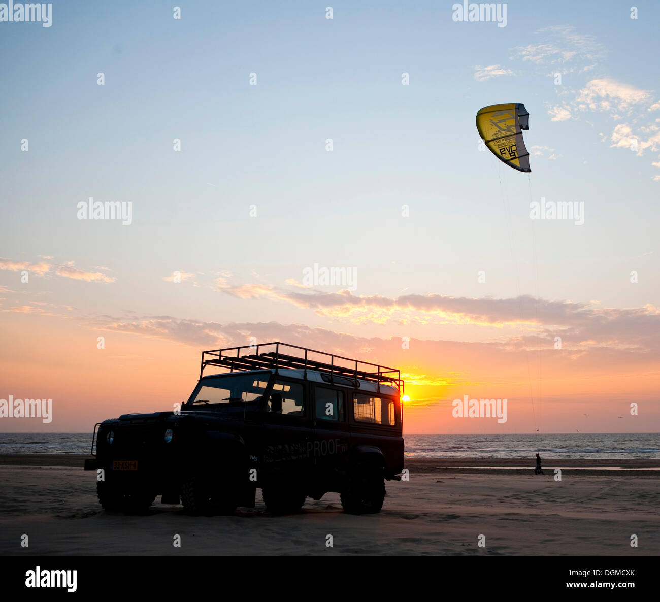 Silhouette d'un véhicule hors route et un kite surfer sur la plage d'Egmond aan Zee, Pays-Bas, au coucher du soleil, de l'Europe Banque D'Images