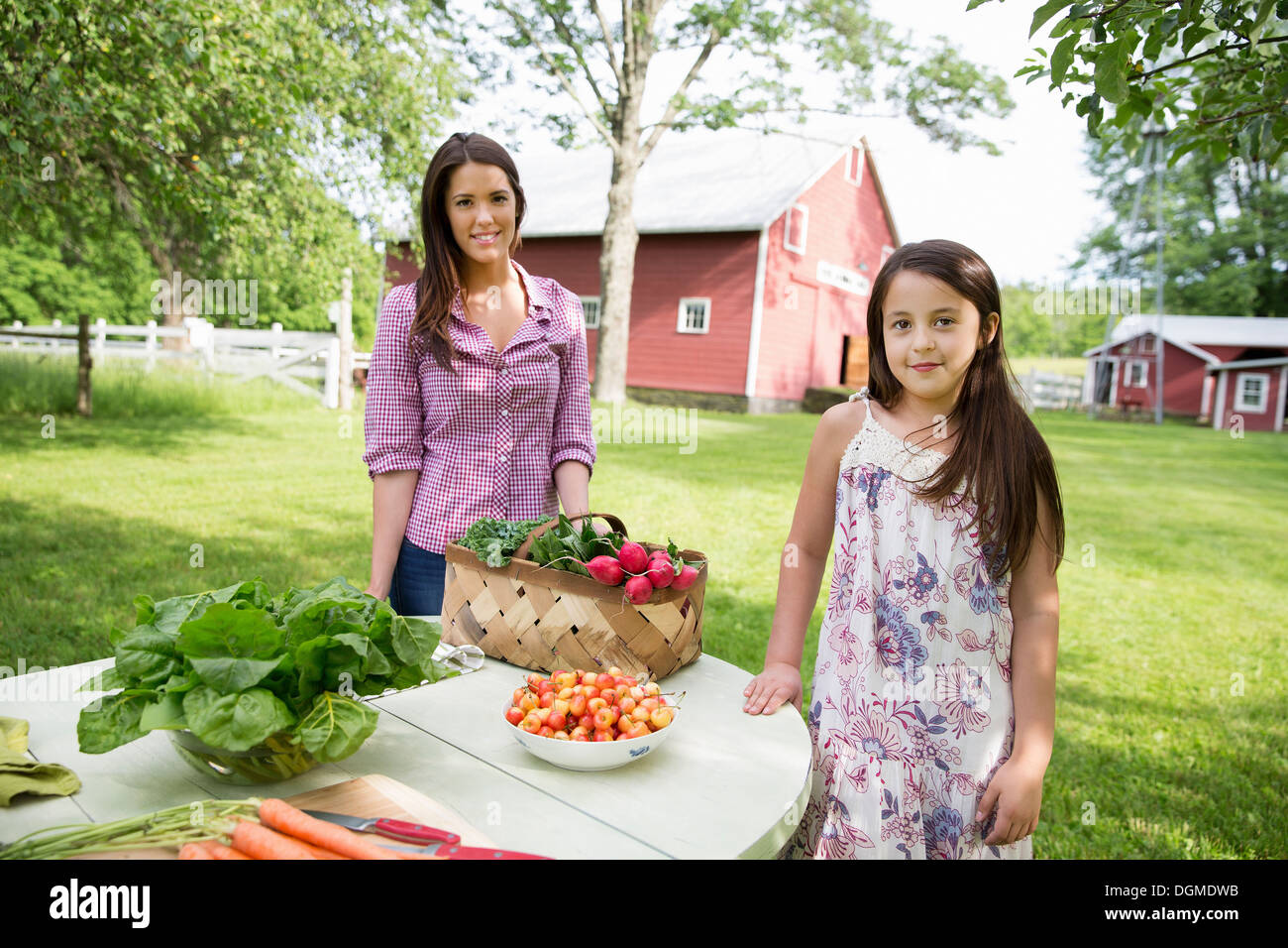 Partie de la famille. Deux personnes, des filles, debout à côté d'un set de table pour un repas d'été. Banque D'Images