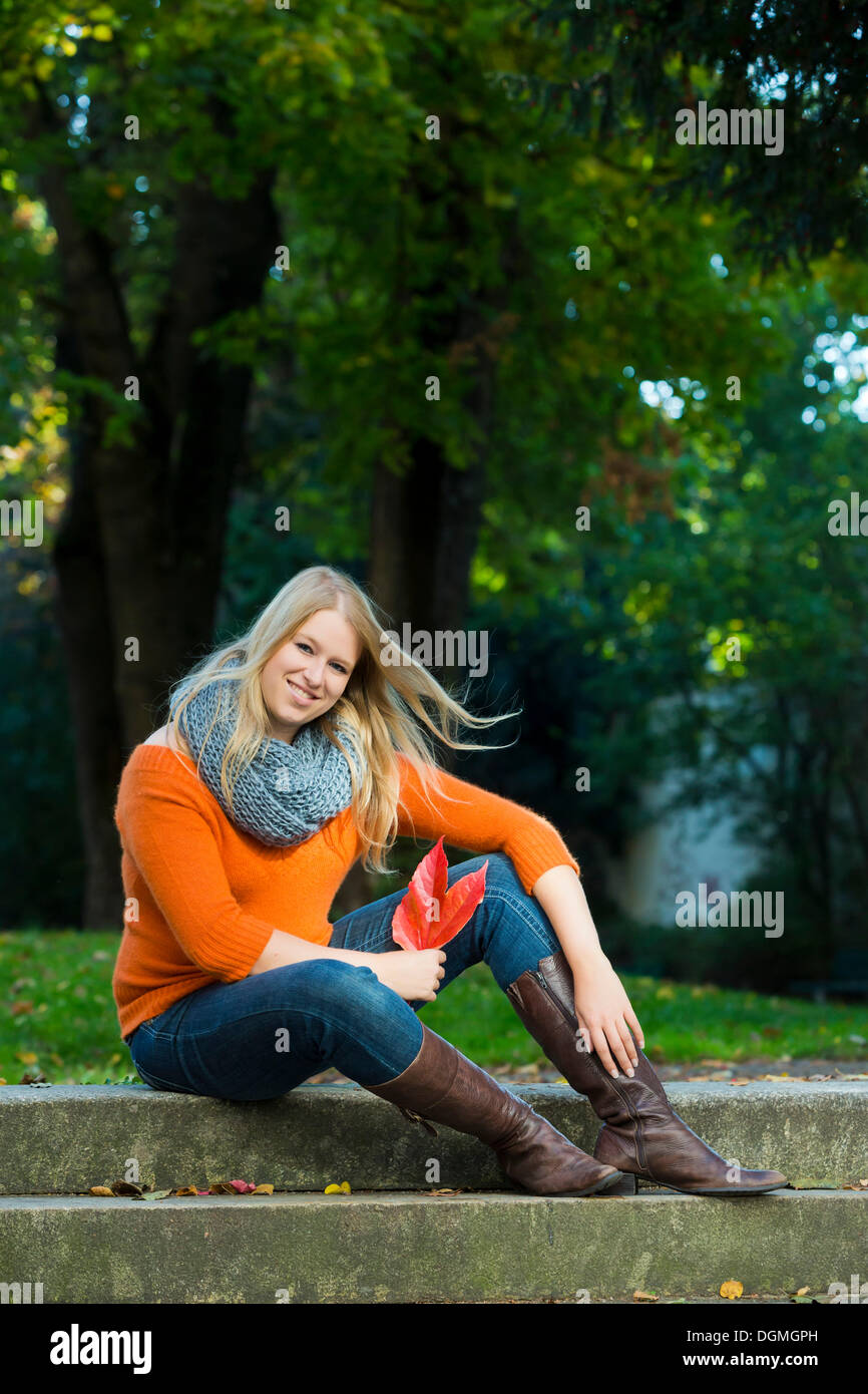 Jeune femme assise sur les marches de pierre Banque D'Images