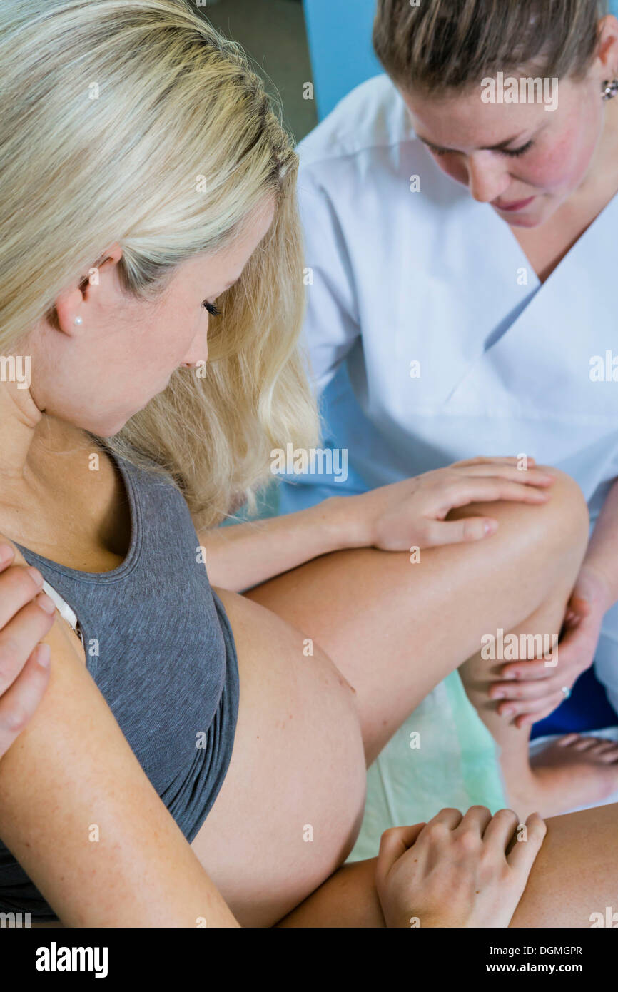 L'homme et de la femme dans la salle d'accouchement pendant l'accouchement, la femme est assise sur un tabouret à la naissance pendant le travail et est appuyé Banque D'Images