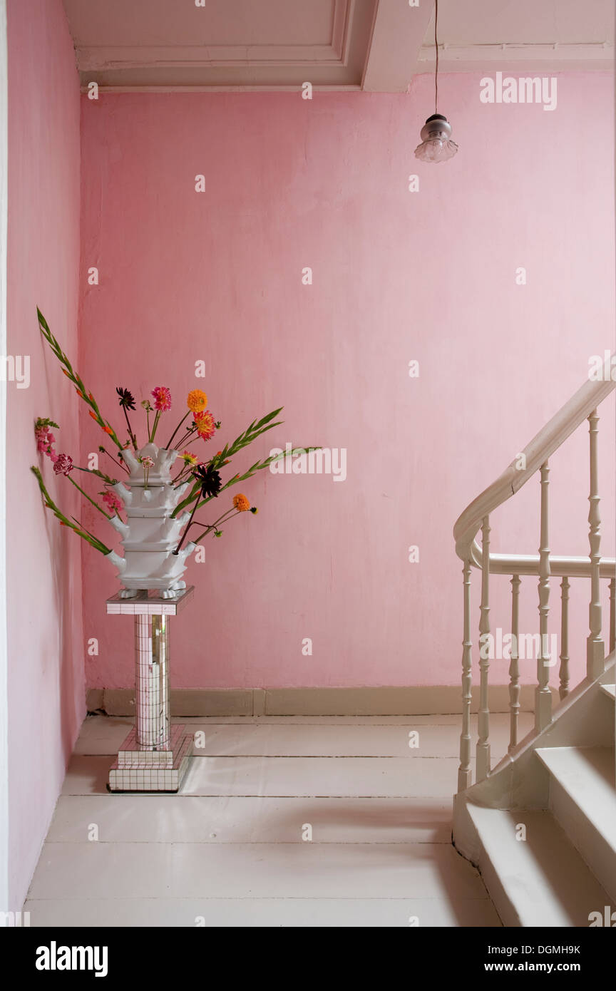 Vase à fleurs rose pastel dans la base du couloir avec Bannister Banque D'Images