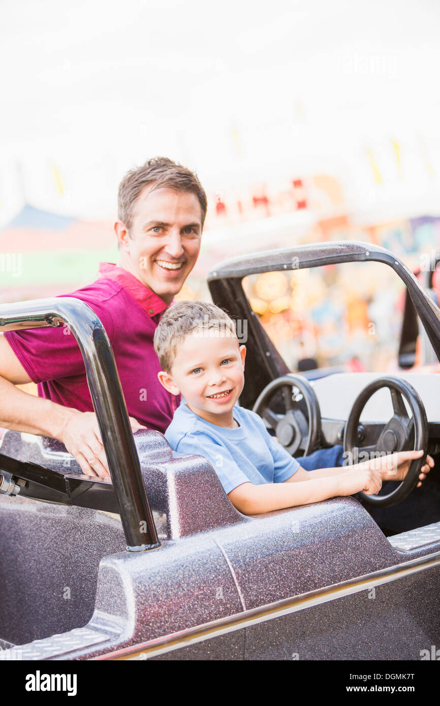 USA, Utah, Salt Lake City, le père avec son (4-5) conduite en voiture jouet amusement park Banque D'Images