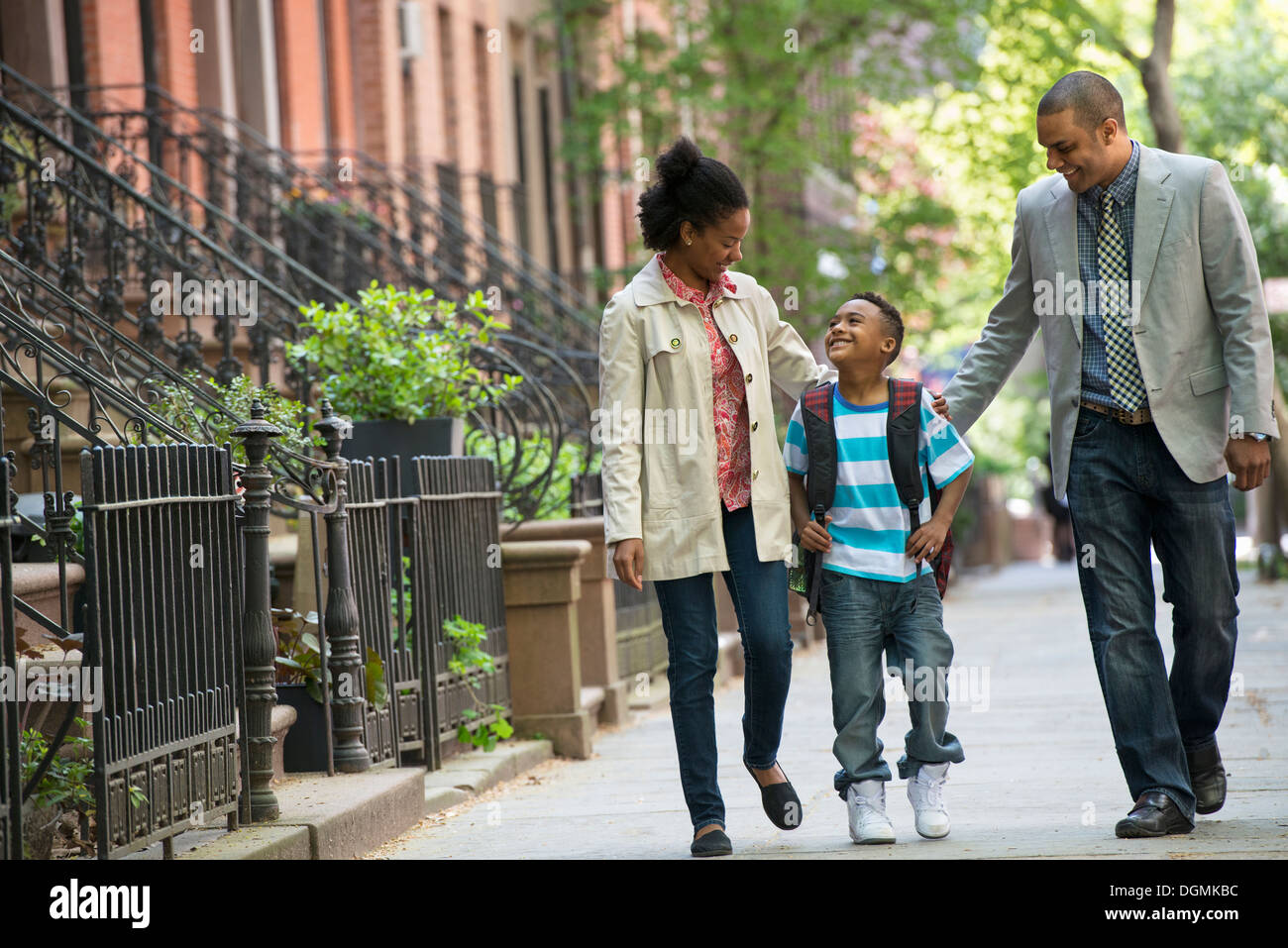 Une famille en plein air dans la ville. Deux parents et un jeune garçon marchant ensemble. Banque D'Images