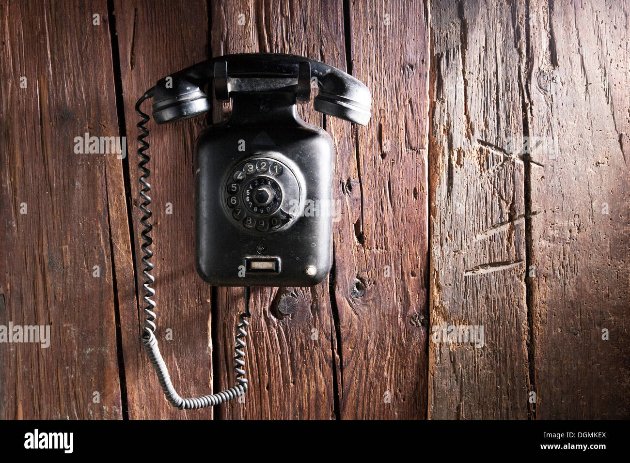 Ancien téléphone mural en bakélite de 1950, hanging on a rustic wooden wall Banque D'Images