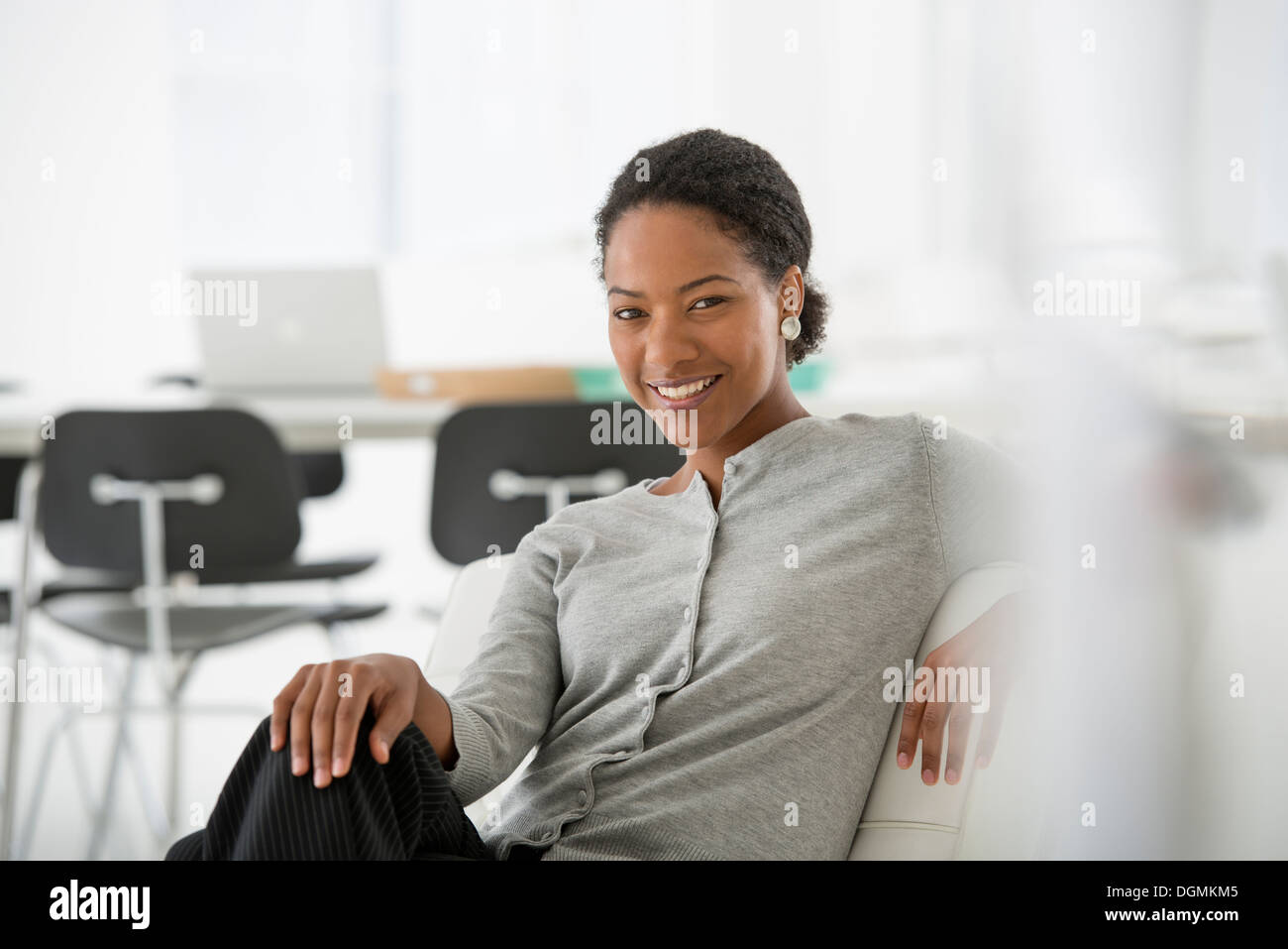 L'entreprise. Une femme assise sur le canapé à la détendre. Banque D'Images L'entreprise. Une femme assise sur le canapé à la détendre. Banque D'Images