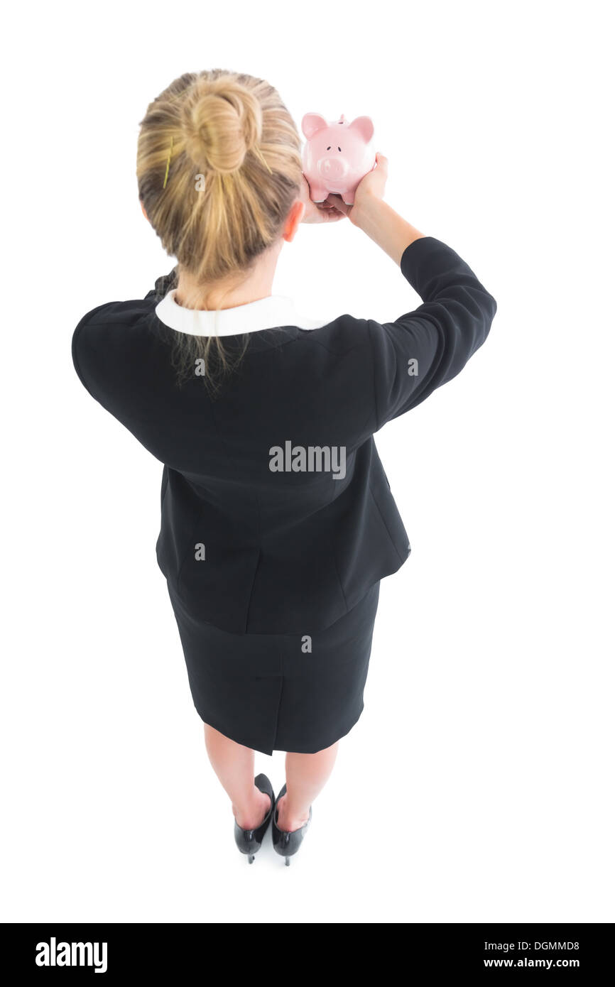 Young businesswoman showing a piggy bank Banque D'Images