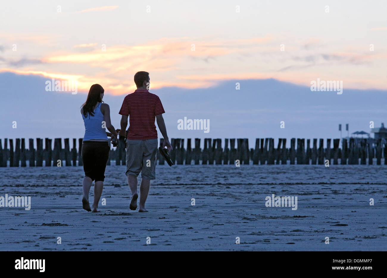 Jeune couple de prendre une marche sur la plage au coucher du soleil, Zoutelande, presqu'île de Walcheren, province de Zélande, Pays-Bas, Benelux Banque D'Images