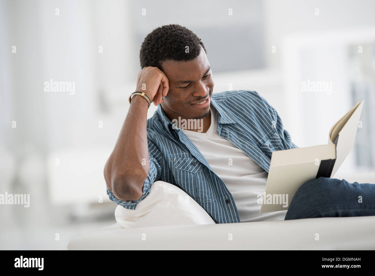 Une lumière blanche intérieur. Un homme en train de lire un livre. Banque D'Images